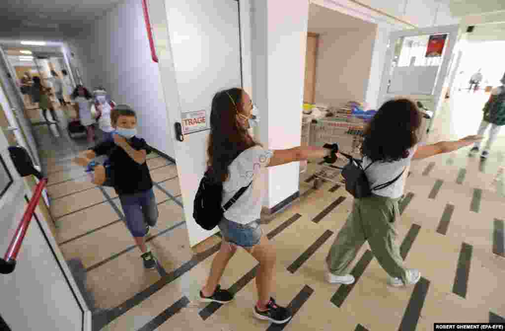 Children rush through the corridor toward their classroom after passing medical checks during the first day of school at the George Enescu National College of Music in Bucharest, Romania, on September 14. 