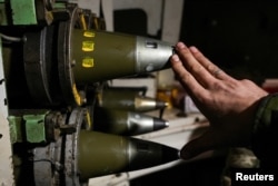 A Ukrainian soldier shows 155mm shells inside a self-propelled howitzer near the frontline town of Bakhmut.