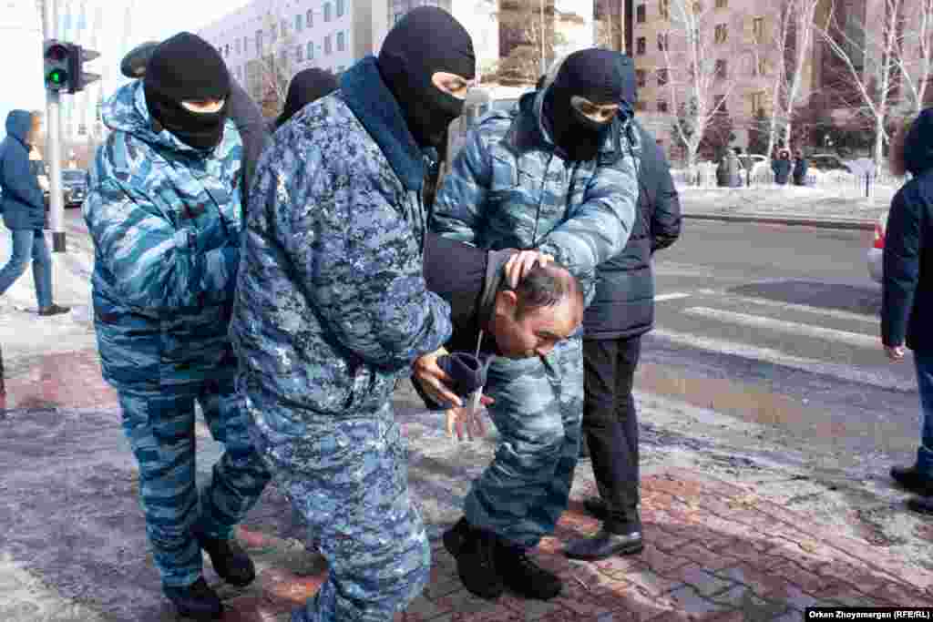 Нұр-Сұлтанда арнайы жасақ белсенді Айсұлтан Жақыповты ұстап әкетіп барады. 