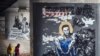 Járókelők Eva Buszevics Navalnijt ábrázoló graffitije előtt Moszkva közelében, 2021. április 6-án. A bebörtönzött ellenzéki vezetőt ábrázoló kép ihletője Mihail Vrubel orosz festő 1890-ben készült képe, Az ülő démon volt