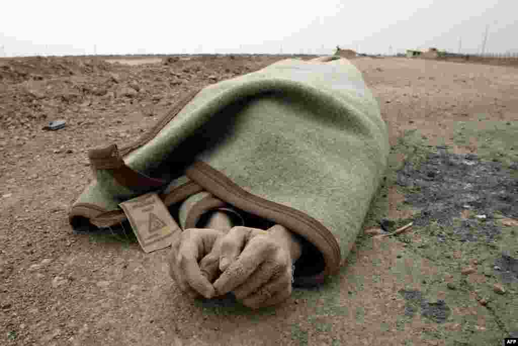 The body of an Iraqi soldier lies wrapped in a blanket following the British assault on the Al-Faw peninsula on March 22.