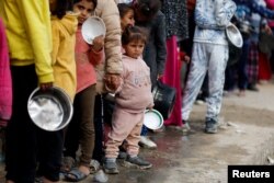 Palestinezët duke pritur në radhë për të marrë ushqim në Rafah.