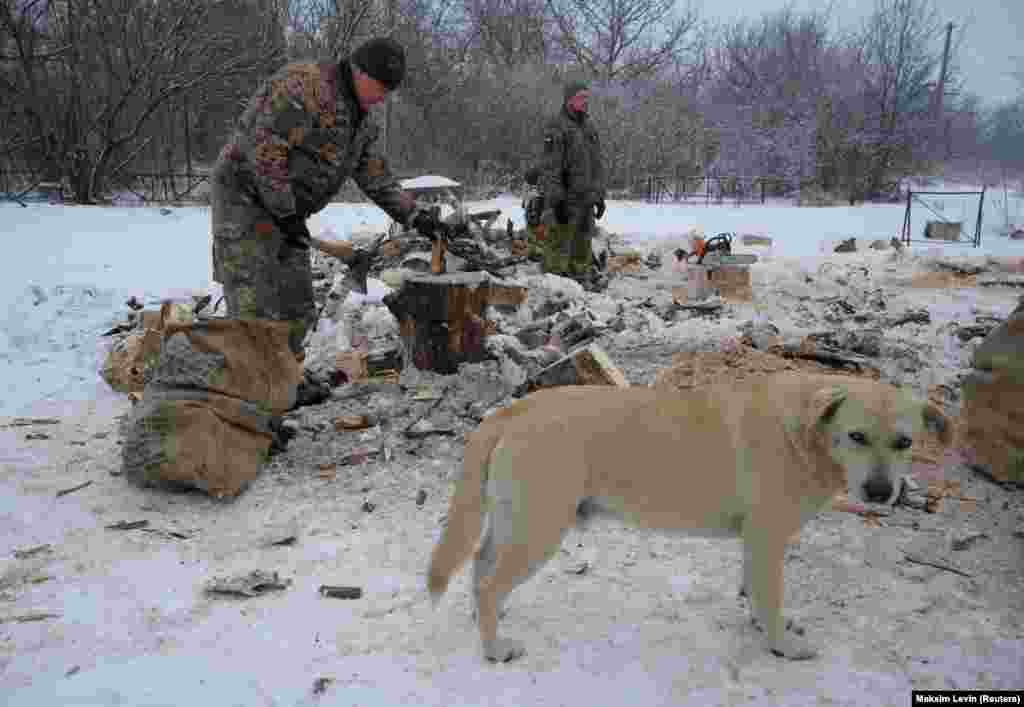 Një ushtar ukrainas pren dru në vijën e frontit në afërsi të fshatit Pisky në rajonin e Donetskut më 29 janar. 