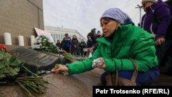 A woman lights candles in Almaty on February 13 in memory of those killed, 40 days after the January unrest.
