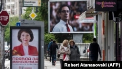Njerëzit kalojnë pranë bilbordeve të dy kandidatëve për president të Maqedonisë së Veriut, Stevo Pendarovskit dhe Gordana Siljanovska-Davkova. Shkup, 18 prill, 2019.