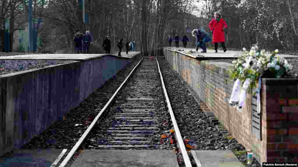Njerëzit vizitojnë memorialin Gleis 17 (Platforma 17), një platformë në stacionin e trenit Berlin-Grunewald nga ku qytetarët hebrenj u dëbuan me tren dejt kampeve të përqendrimit nazist, mes viteve 1941 dhe 1945, në Berlin, Gjermani, 27 janar 2021.