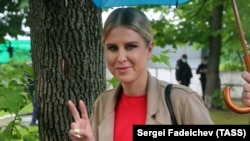 Ljubov Szobol a győzelem jelét mutatja, miközben a bíróságra tart Moszkvában. 2021. június 8. 