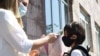 Armenia -- A teacher measures a first grader's temperature at the entrance to a school in Yerevan, September 14, 2020.