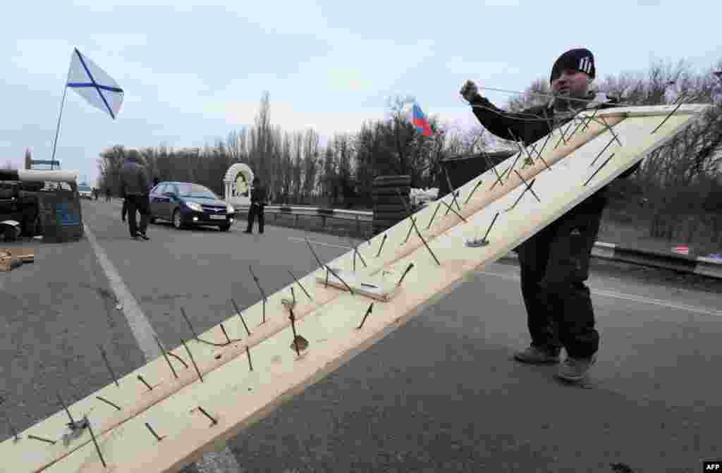 Мужчина пытается заблокировать соединяющую полуостров Крым с материком дорогу в районе города Армянска.