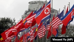 Государственные флаги США, Северной Кореи и Вьетнама подняты перед международным пресс-центром в Ханое. 25 февраля 2019