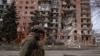 Украински военен е заснет пред разрушена от руските военни жилищна сграда в град Покровск.