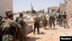 Syria -- Government forces carry their weapons as they move during what they said was an operation to push rebels from the road between Dahra Abd Rabbo village and Castello in Aleppo, 27May2013