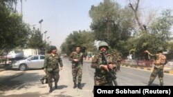 Security forces are seen near the site where a suicide bomber blew himself up in the center of Kabul on September 5.