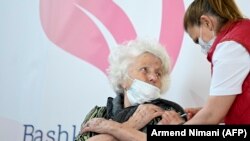 Një grua merr dozën e saj të parë të vaksinës AstraZeneca Covid-19 në një qendër vaksinimi në Prishtinë, 13 prill 2021. 