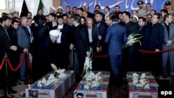 Iranian President Hassan Rohani (left) prays near the coffins of victims who died in a terror attack at the Iranian parliament in Tehran.