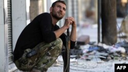 A Syrian rebel fighter watches the sky after hearing a helicopter Aleppo's al-Amiriya neighborhood on September 24.
