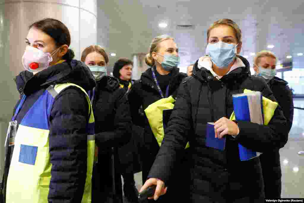 Ukraine International Airlines crew members wear protective masks while taking safety precautions as they arrive at the Boryspil International Airport outside Kyiv.