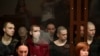 Captured members of Ukraine's Azov Battalion sit inside a defendants' glass cage during a hearing at a court in Rostov-on-Don, Russia. 